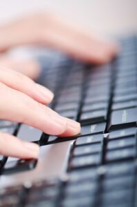 Female hands typing on a computer keyboard to illustrate Style Sheets For Content Consistency — One Client At A Time